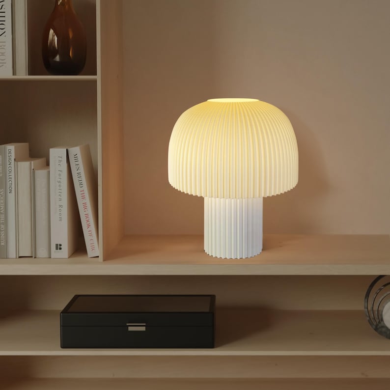 Table lamp with ribbed design on a shelf with books and a box